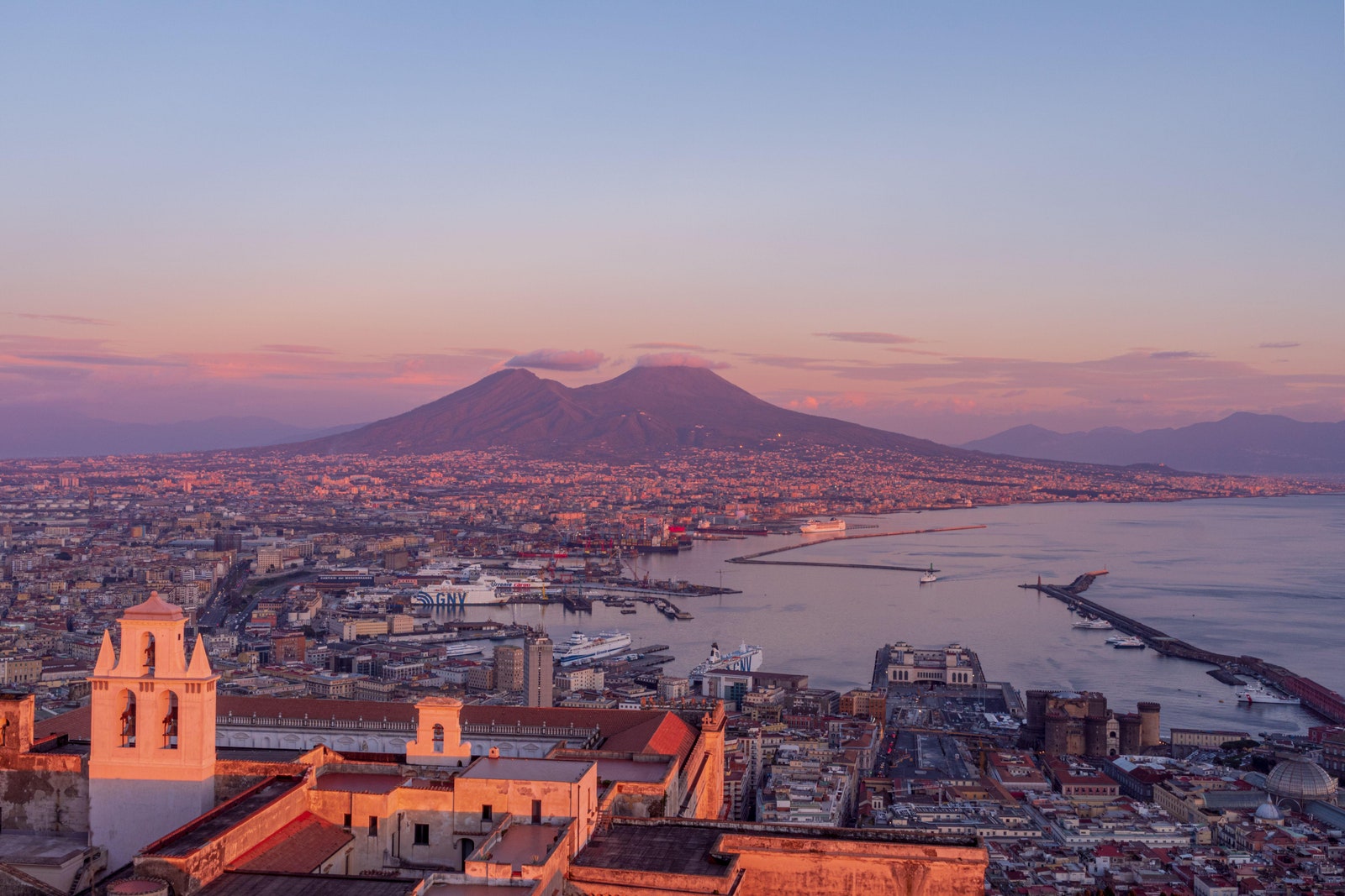 2HMK6DW Naples Italy 23 January 2022 Naples during a pinky sunset in the backgroung Vesuvius