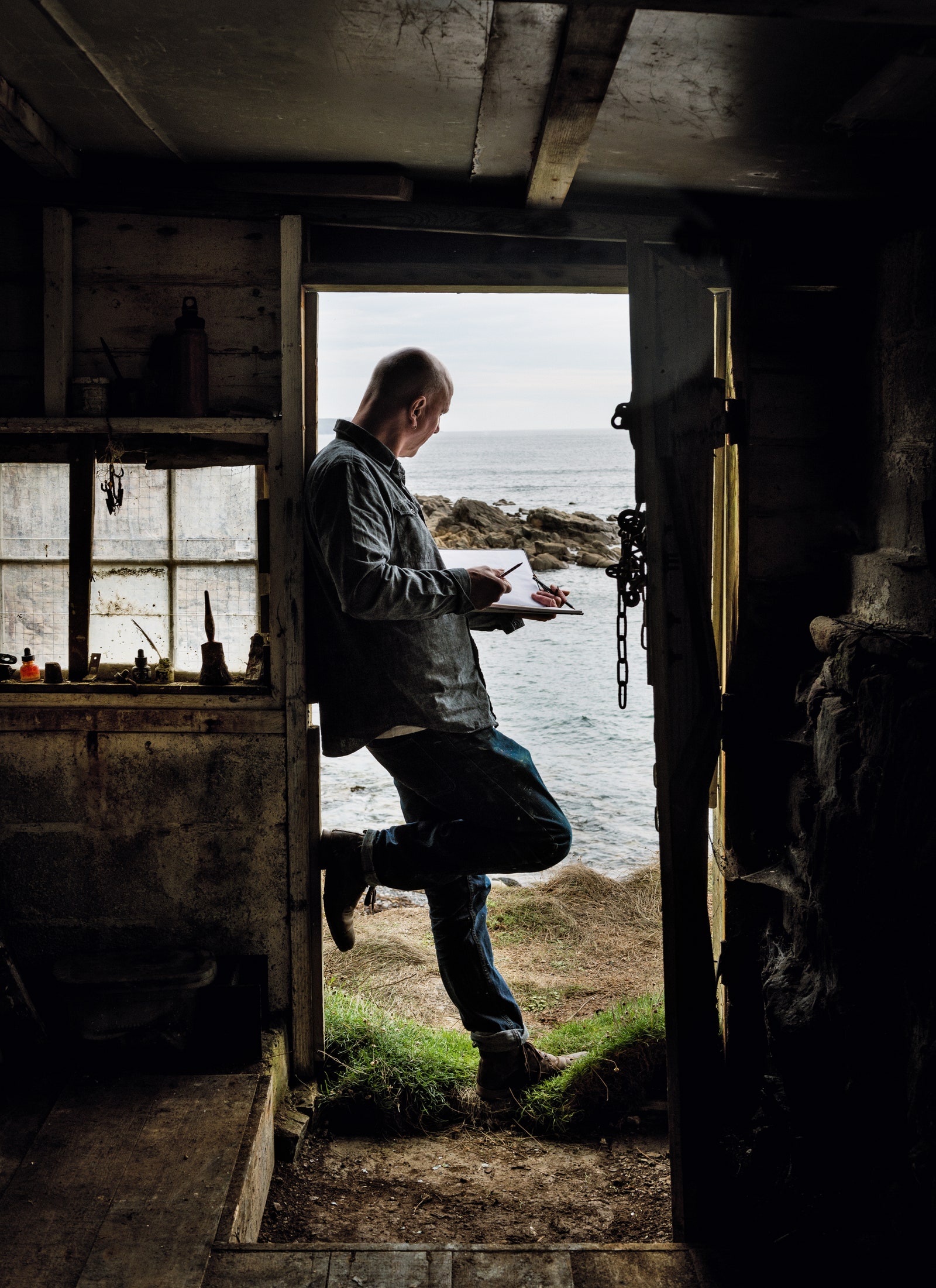 Sketching the sea from the doorway of his clifftop studio